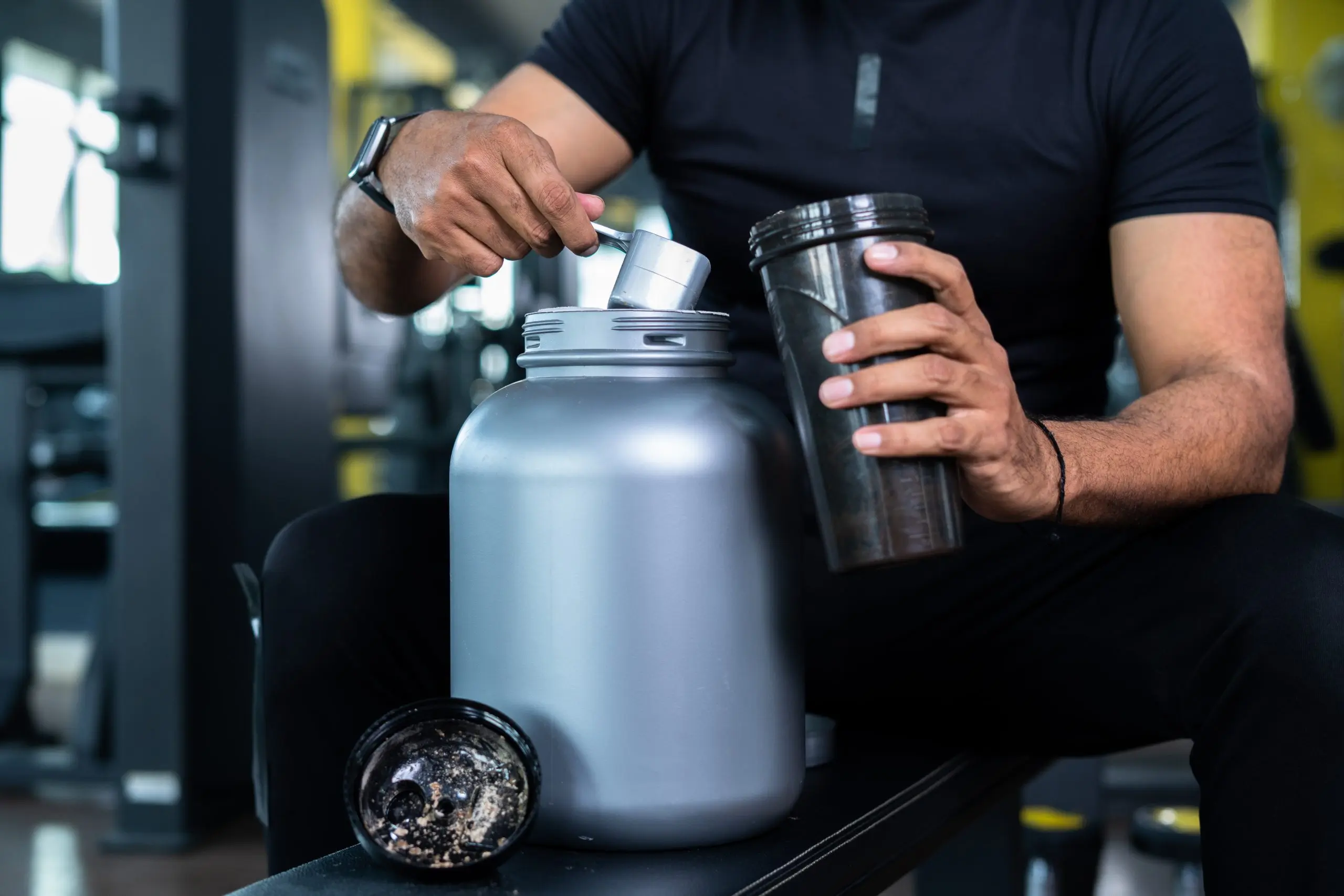 Close up shot of bodybuilder hands taking protein powder