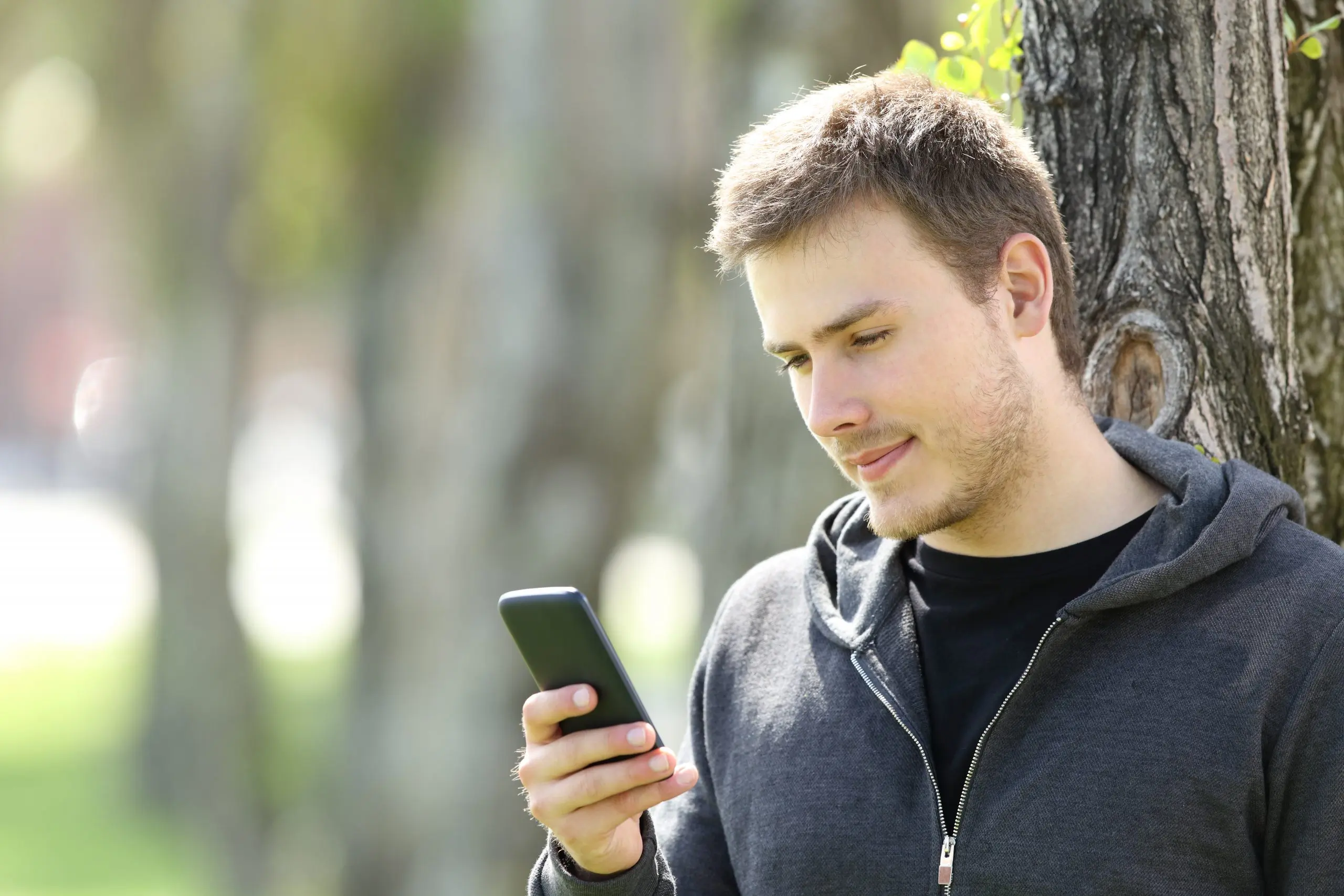 Serious man using a smart phone to speak to an online doctor